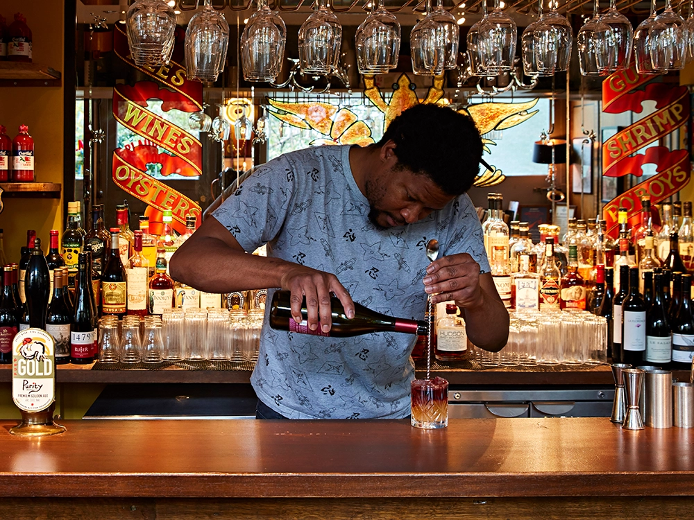 Bartender at Plaquemine Lock Islington Angel Bartender mixing cocktail at Plaquemine Lock pub in Angel Islington, a venue for private dining and Christmas parties