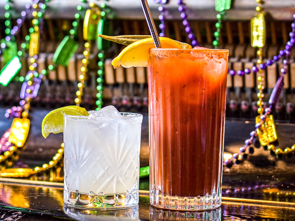 Cocktails at Plaquemine Lock Angel Islington Two cocktails with lime and lemon garnish at Plaquemine Lock pub in Islington Angel with Mardi Gras beads, perfect for private dining and Christmas events